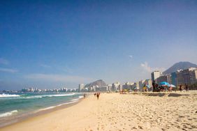 Wide shot of Copacabana beach with the skyline and the mountain in the background